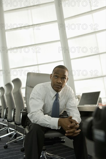 African businessman in conference room looking impatient