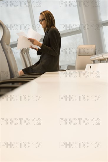 African businesswoman reviewing paperwork in conference room