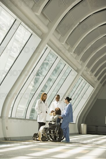 Multi-ethnic doctors and nurse with patient in wheelchair