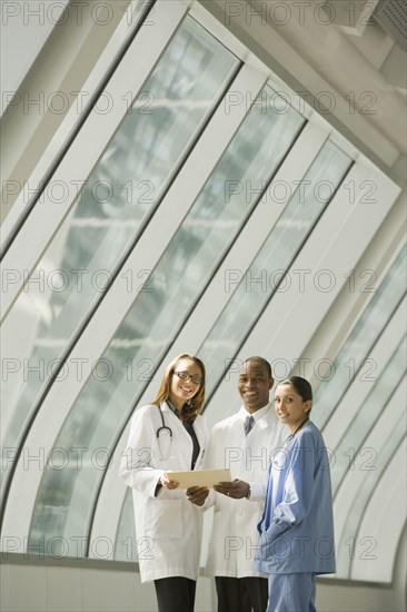 Multi-ethnic doctors and nurse posing by window