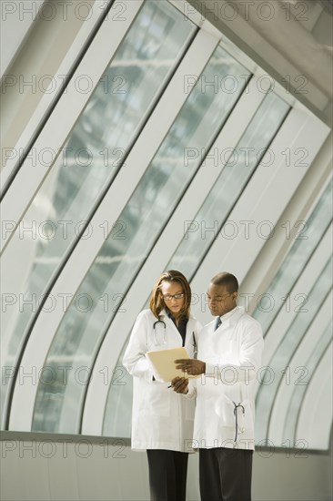 African doctors reviewing medical chart in corridor