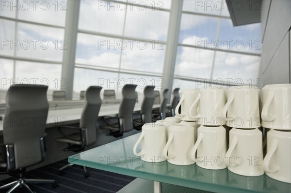 Stack of coffee mugs in conference room