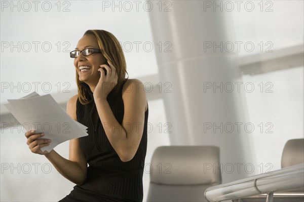 African businesswoman talking on cell phone in conference room