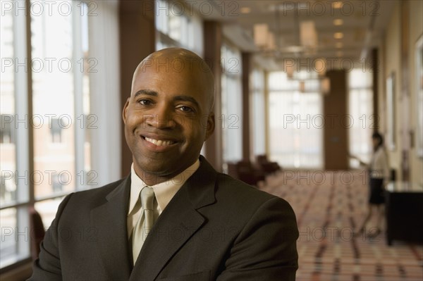 African businessman smiling in hotel corridor