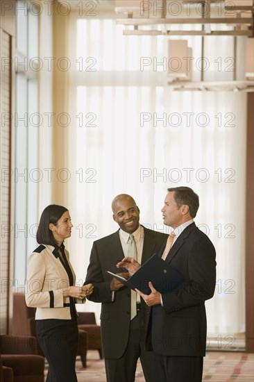 Multi-ethnic business people talking in corridor