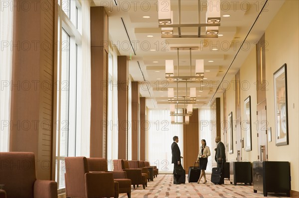 Multi-ethnic business people with suitcases in hotel