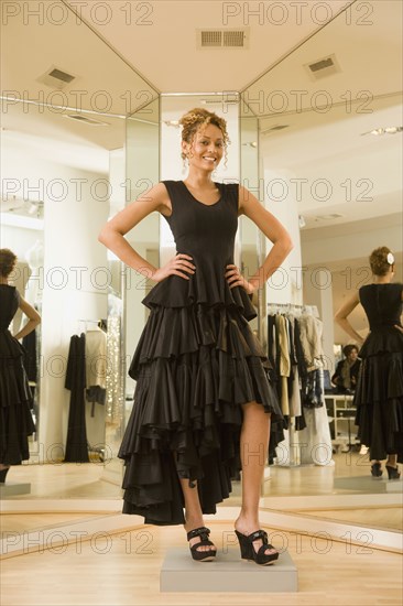 Mixed race woman trying on flamenco dress in shop