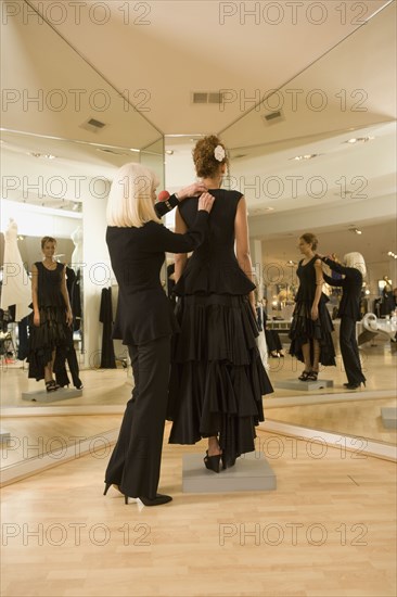 Mixed race woman having flamenco dress fitted by tailor