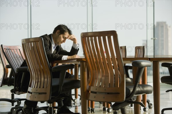 Worried businessman waiting in conference room for meeting