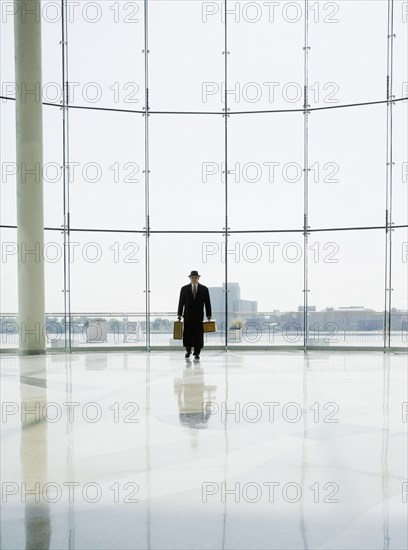 Hispanic man holding luggage in airport