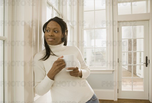 African woman holding coffee cup