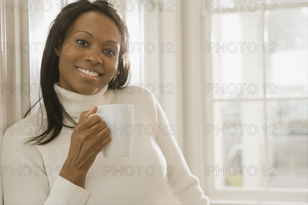 African woman holding coffee cup