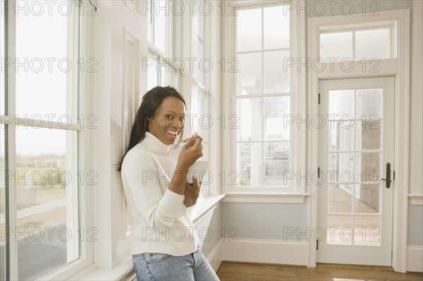 African woman eating in empty room
