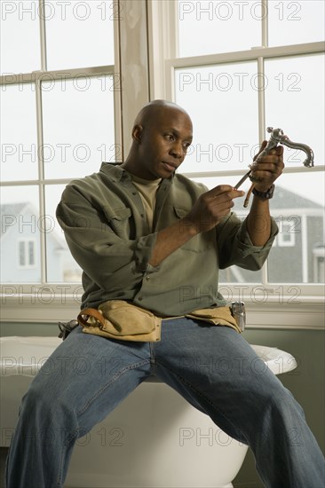 African plumber repairing faucet