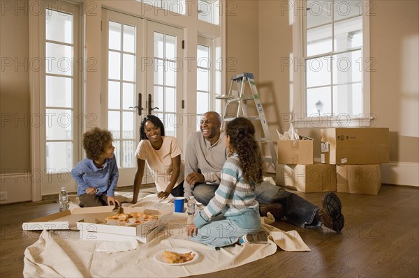 Family eating on floor in new home