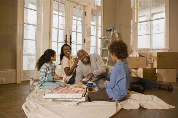 Family eating on floor in new home