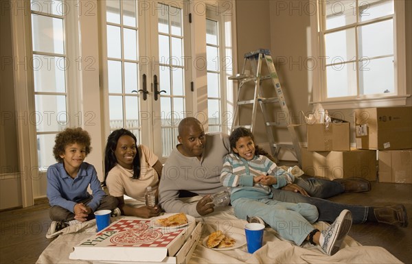 Family eating on floor in new home