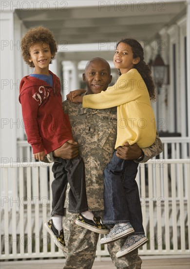 African soldier holding son and daughter