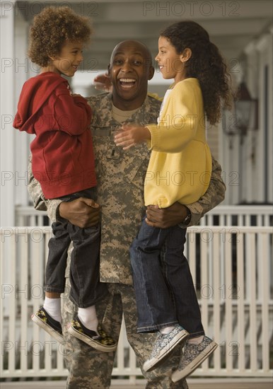 African soldier holding son and daughter