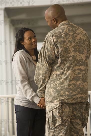 African soldier and girlfriend holding hands