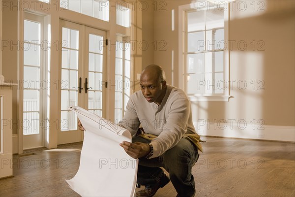 African man holding blueprint