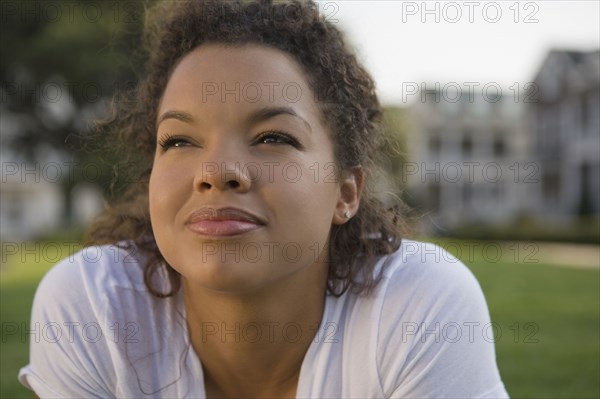 Mixed race woman looking up outdoors