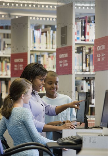 Teacher and students researching in library