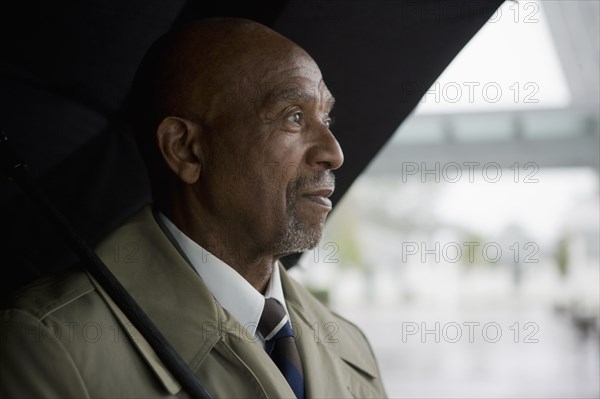 African businessman holding umbrella