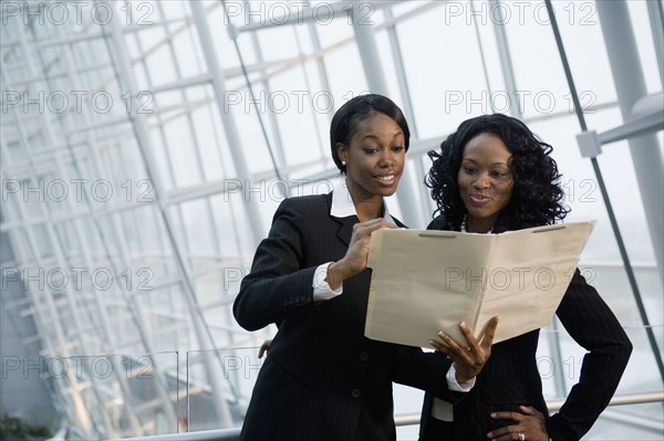 African businesswomen viewing folder