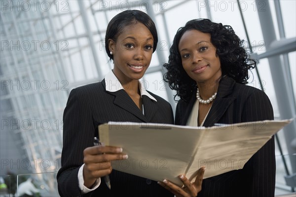 African businesswomen viewing folder