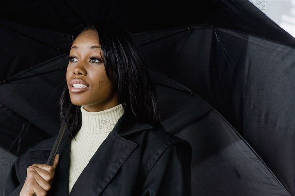 African businesswoman holding umbrella