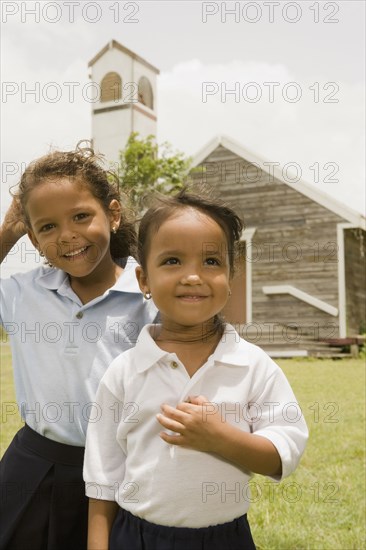 Hispanic sisters standing outside church