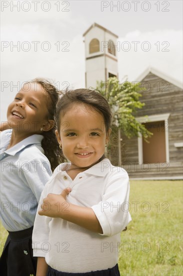 Hispanic sisters standing outside church