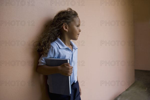 Hispanic school girl holding textbook