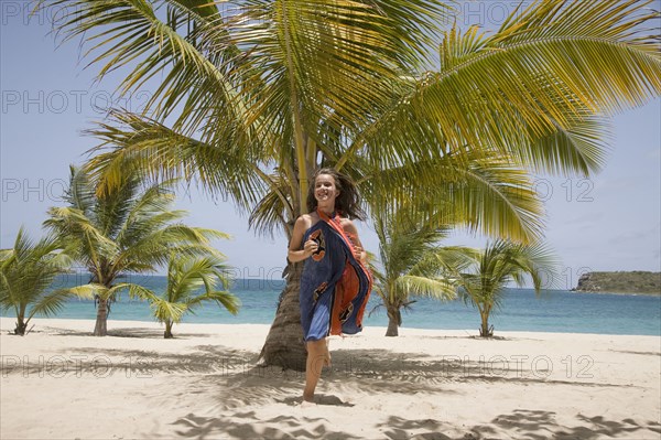 Girl in sarong running on beach