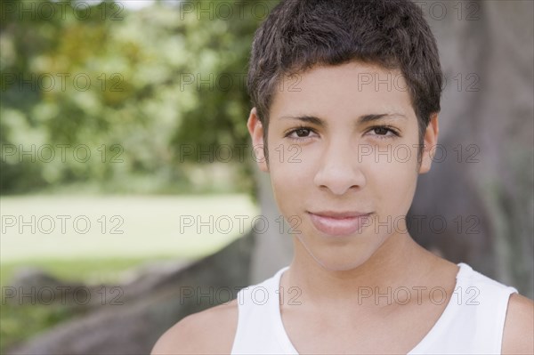 Smiling Hispanic teenage boy standing outdoors
