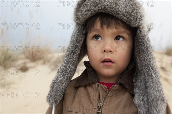 Mixed race boy wearing fur hat