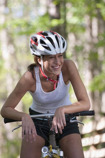 Hispanic woman sitting on bicycle