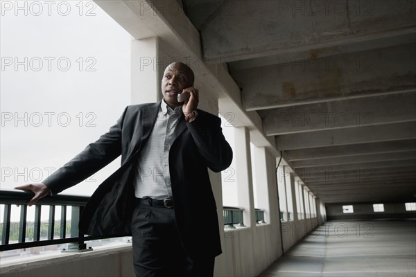 African businessman talking on cell phone in parking garage