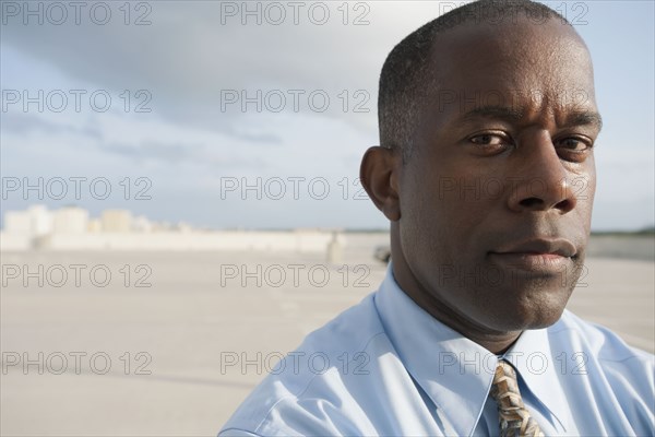 African businessman standing in parking lot