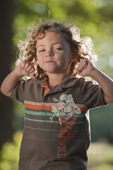 Mixed race girl grimacing with arms raised