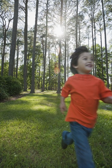 Hispanic boy running in forest