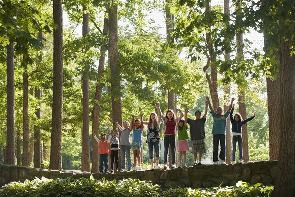 Friends cheering and standing on stone wall