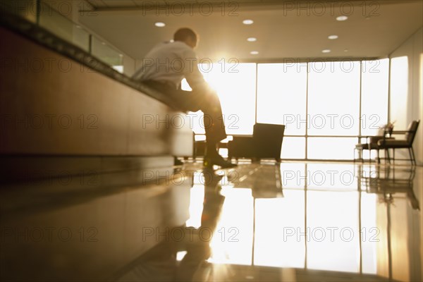 Mixed race businessman sitting in lobby