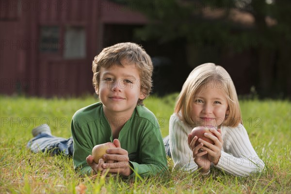 Mixed race brother and sister laying in grass