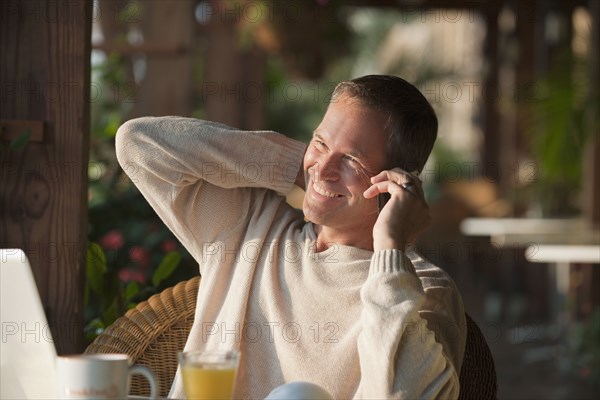 Caucasian man talking on cell phone in restaurant