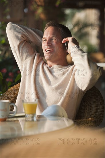 Caucasian man talking on cell phone in restaurant