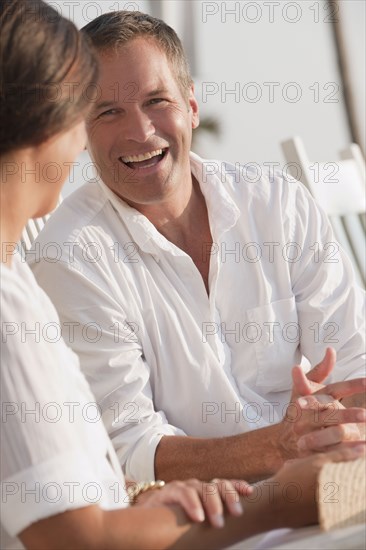 Laughing Caucasian husband talking to wife