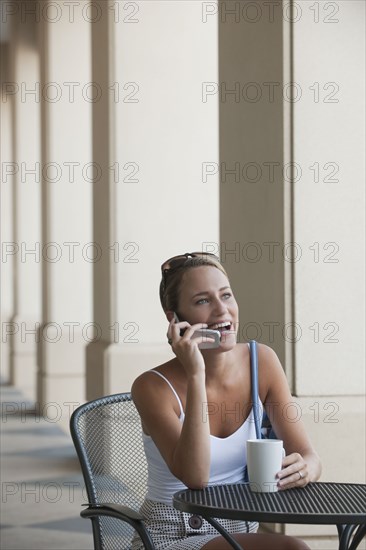 Caucasian woman in cafe talking on cell phone