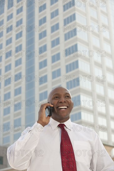 Black businessman talking on cell phone outdoors